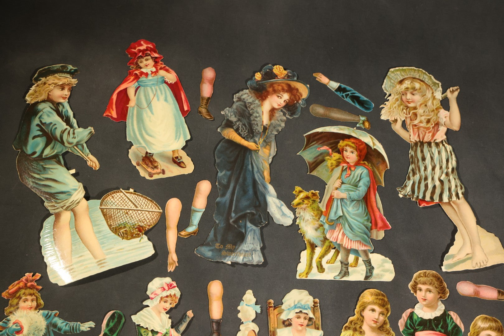 Grouping of 14 Antique Chromolithograph Paper Dolls with Extra Limbs and Accessories Including Raphael Tuck and Sons, Little Red Riding Hood, and Spinning Wheel Figures