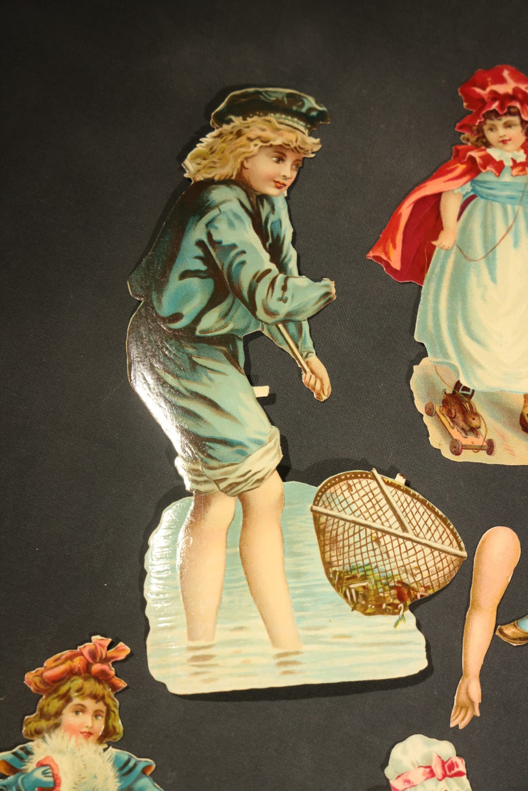 Grouping of 14 Antique Chromolithograph Paper Dolls with Extra Limbs and Accessories Including Raphael Tuck and Sons, Little Red Riding Hood, and Spinning Wheel Figures