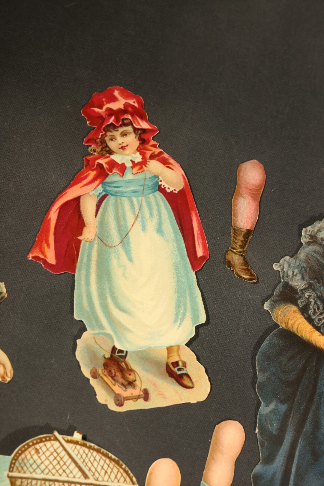 Grouping of 14 Antique Chromolithograph Paper Dolls with Extra Limbs and Accessories Including Raphael Tuck and Sons, Little Red Riding Hood, and Spinning Wheel Figures