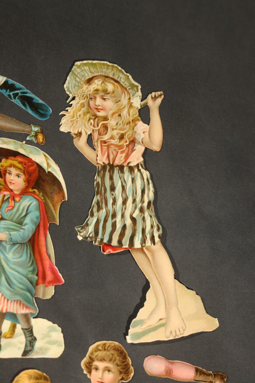 Grouping of 14 Antique Chromolithograph Paper Dolls with Extra Limbs and Accessories Including Raphael Tuck and Sons, Little Red Riding Hood, and Spinning Wheel Figures