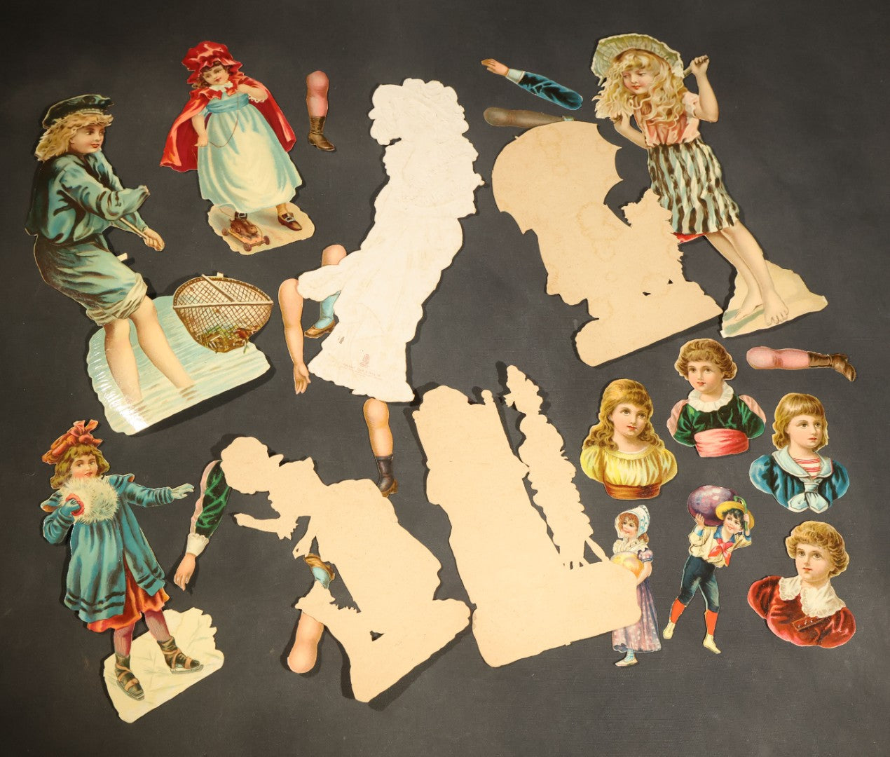 Grouping of 14 Antique Chromolithograph Paper Dolls with Extra Limbs and Accessories Including Raphael Tuck and Sons, Little Red Riding Hood, and Spinning Wheel Figures