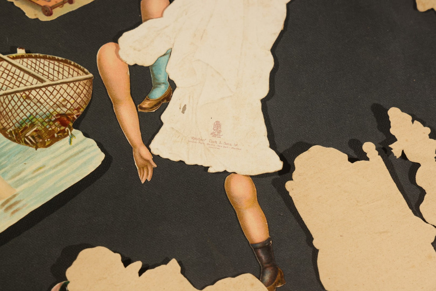 Grouping of 14 Antique Chromolithograph Paper Dolls with Extra Limbs and Accessories Including Raphael Tuck and Sons, Little Red Riding Hood, and Spinning Wheel Figures