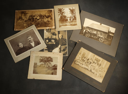 Grouping of Seven Antique Board-Mounted Photographs Including a Church, Street Scene, Couple's Portrait, Family Gathering, School Group, Early Automobile, and Parlor Interior with Telephone