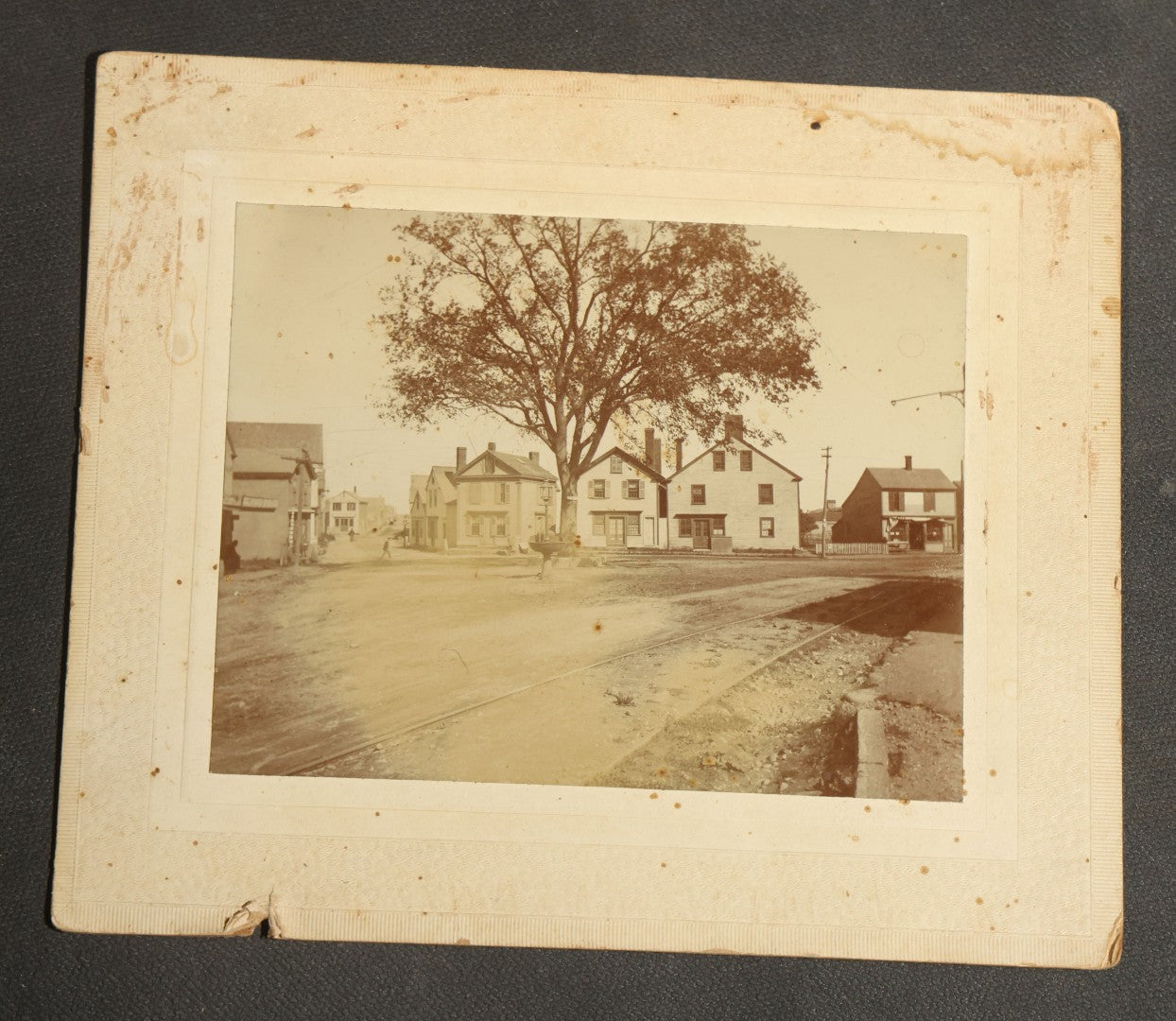 Grouping of Seven Antique Board-Mounted Photographs Including a Church, Street Scene, Couple's Portrait, Family Gathering, School Group, Early Automobile, and Parlor Interior with Telephone
