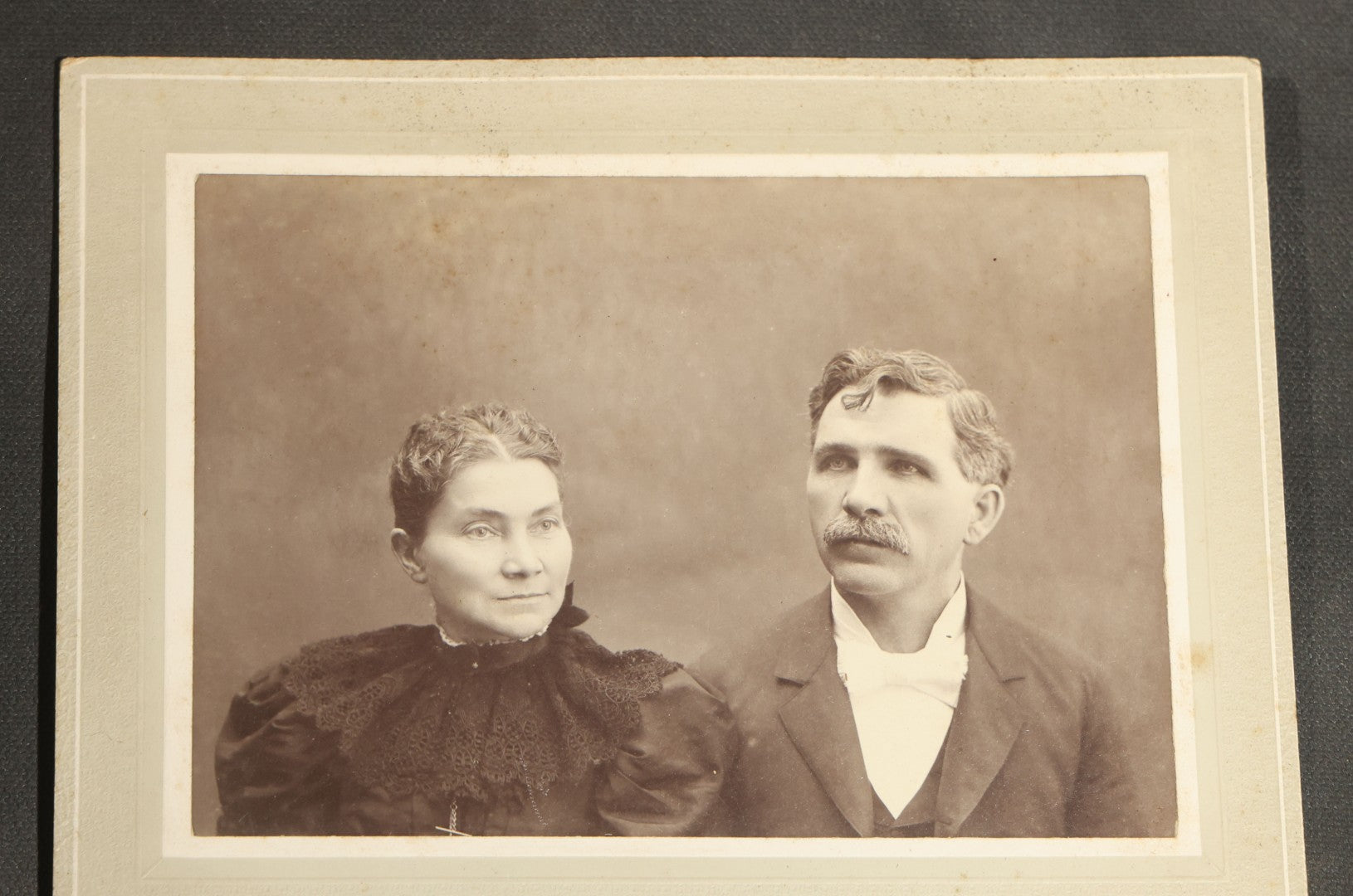 Grouping of Seven Antique Board-Mounted Photographs Including a Church, Street Scene, Couple's Portrait, Family Gathering, School Group, Early Automobile, and Parlor Interior with Telephone