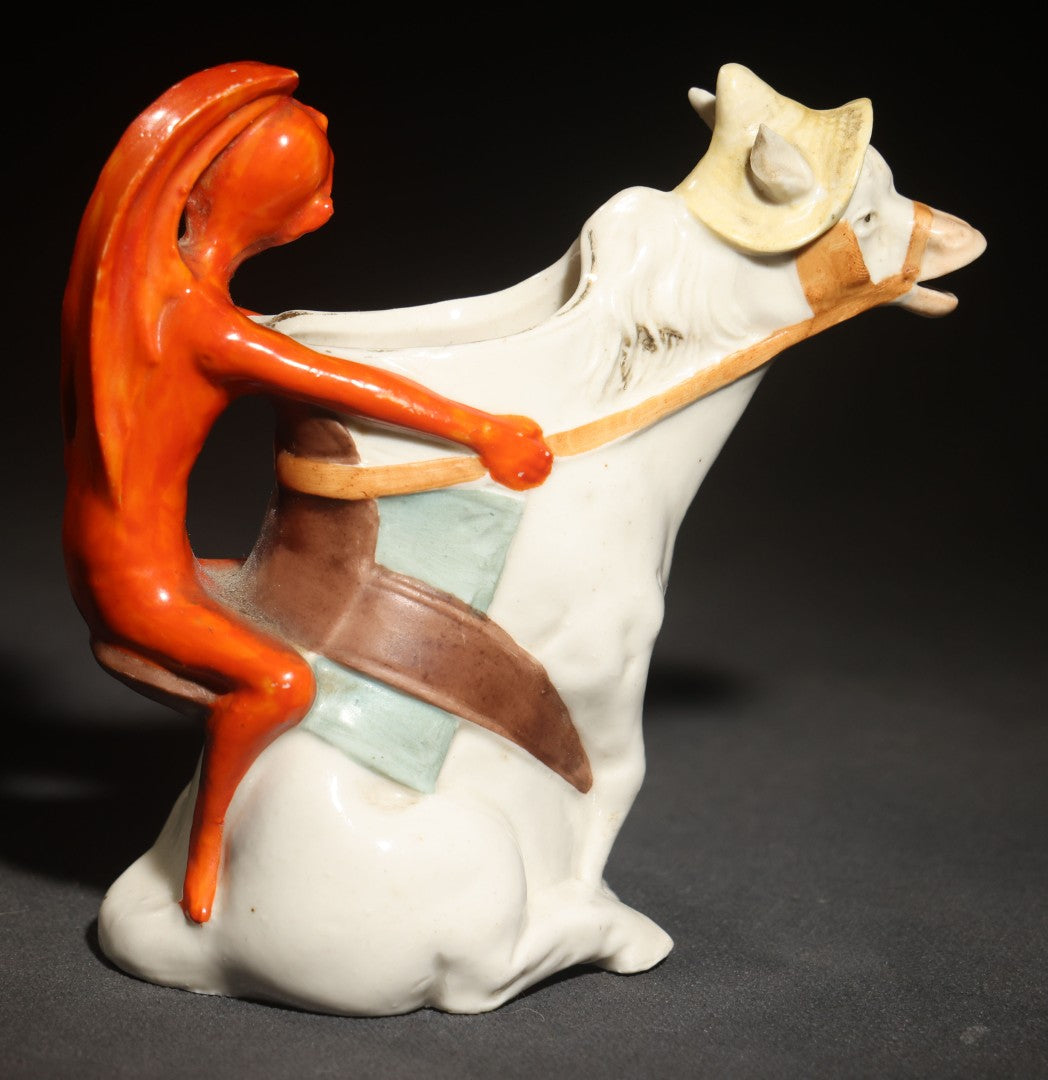 Antique Porcelain Figural Creamer of a Red Devil Riding a White Horse, Likely German, Note Horse Missing Tip of Ear