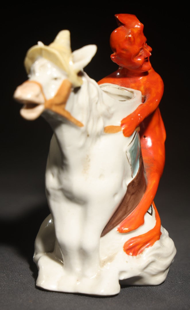 Antique Porcelain Figural Creamer of a Red Devil Riding a White Horse, Likely German, Note Horse Missing Tip of Ear