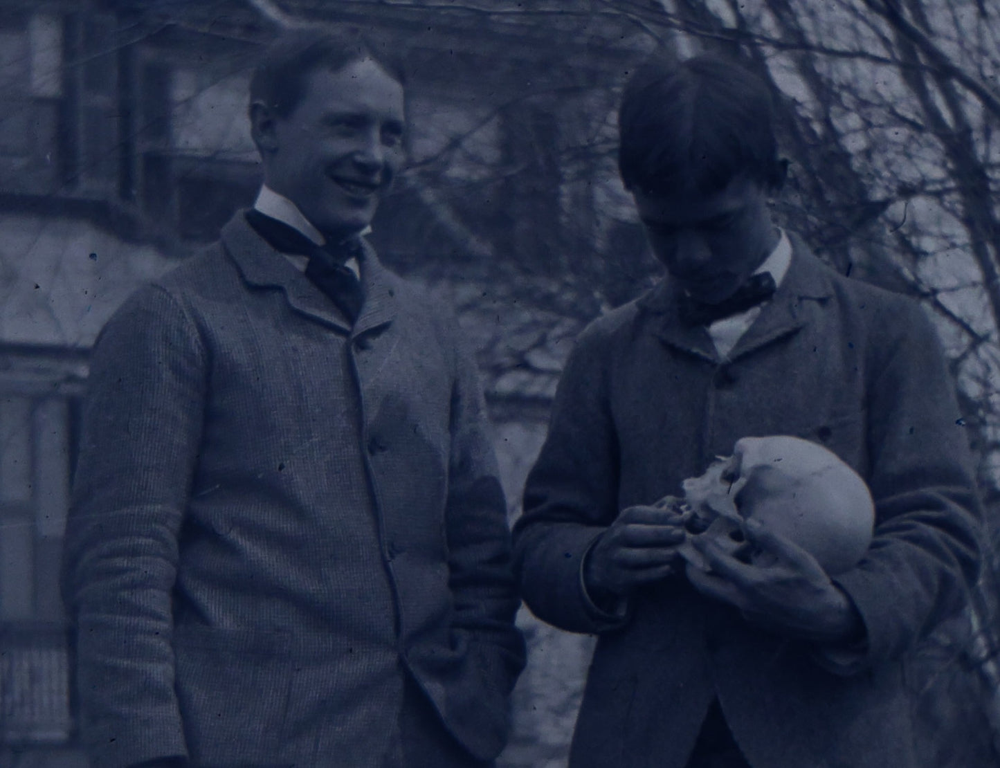 Lot 061 - Single Antique Glass Negative Plate, Man Holding Real Human Skull, With Grinning Man To Left, In Front Of House, Note Edge Cracks (First Photo Is Inverted)