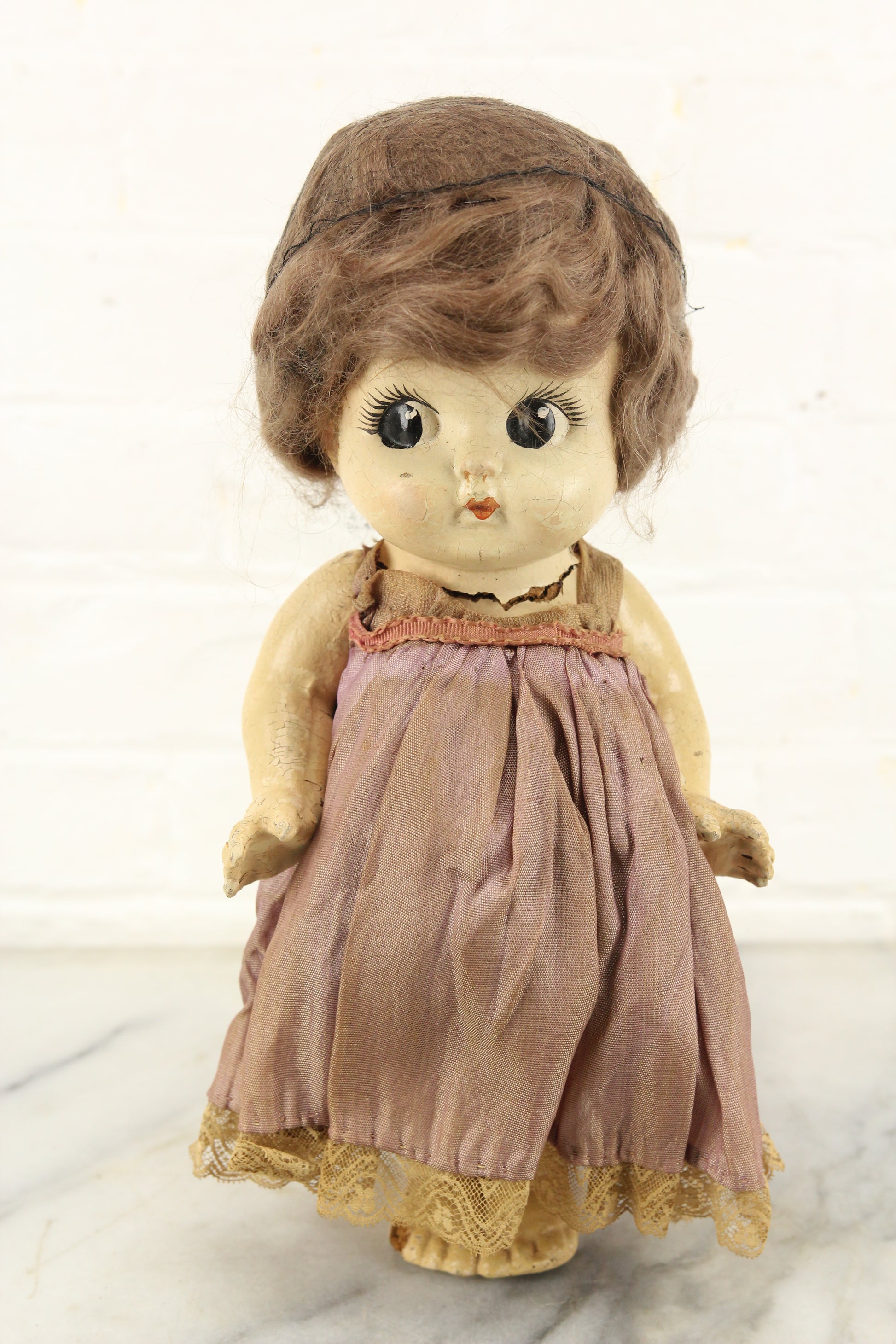 Antique Kewpie Composition Doll with Black Hair Net and Pink Dress