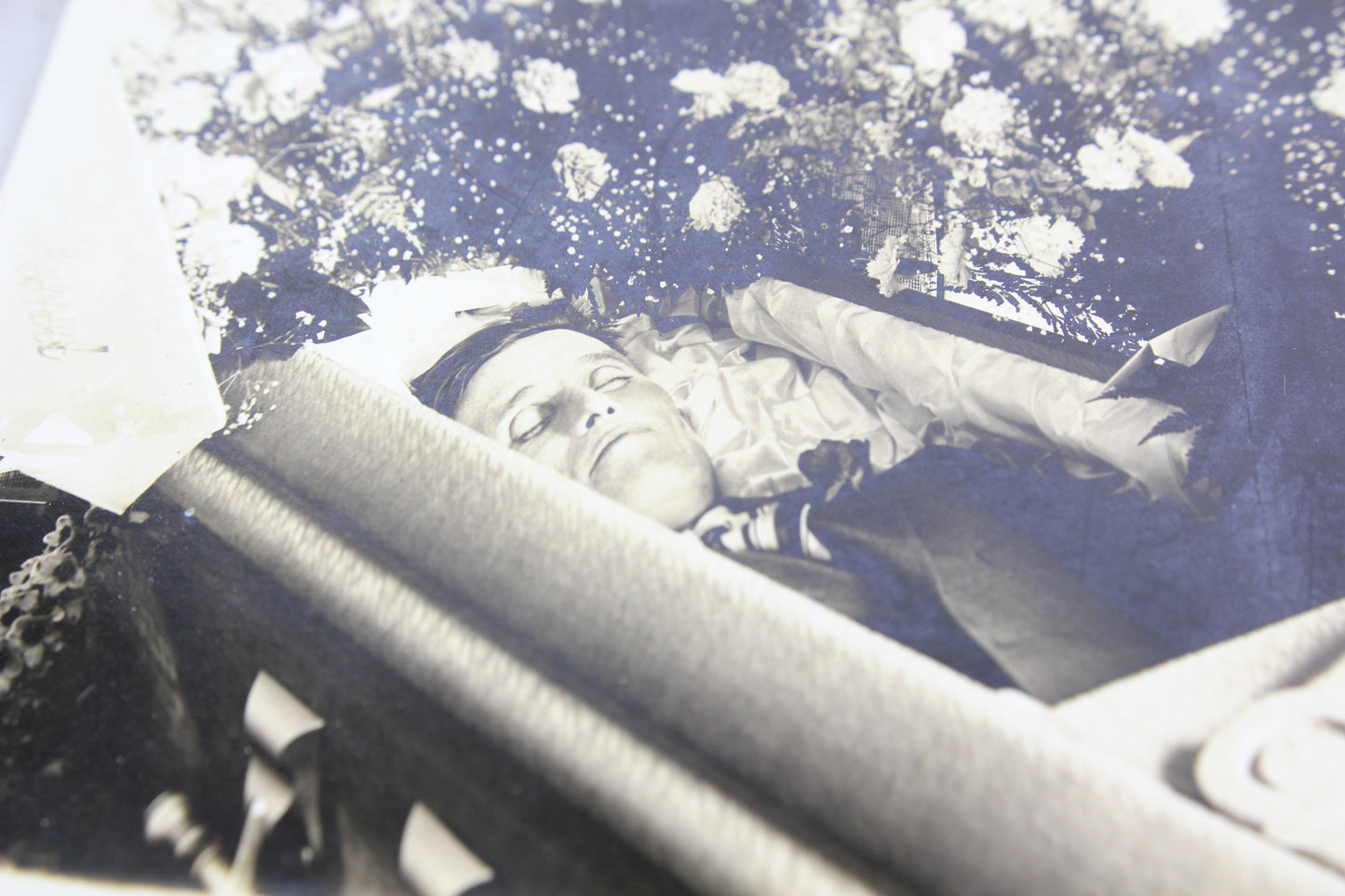 Postmortem Photograph of a Man in His Coffin Surrounded by Flowers