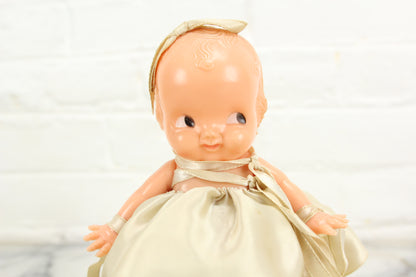 Irwin Kewpie Style Celluloid Baby Doll with Dress and Bow on Base, 6"