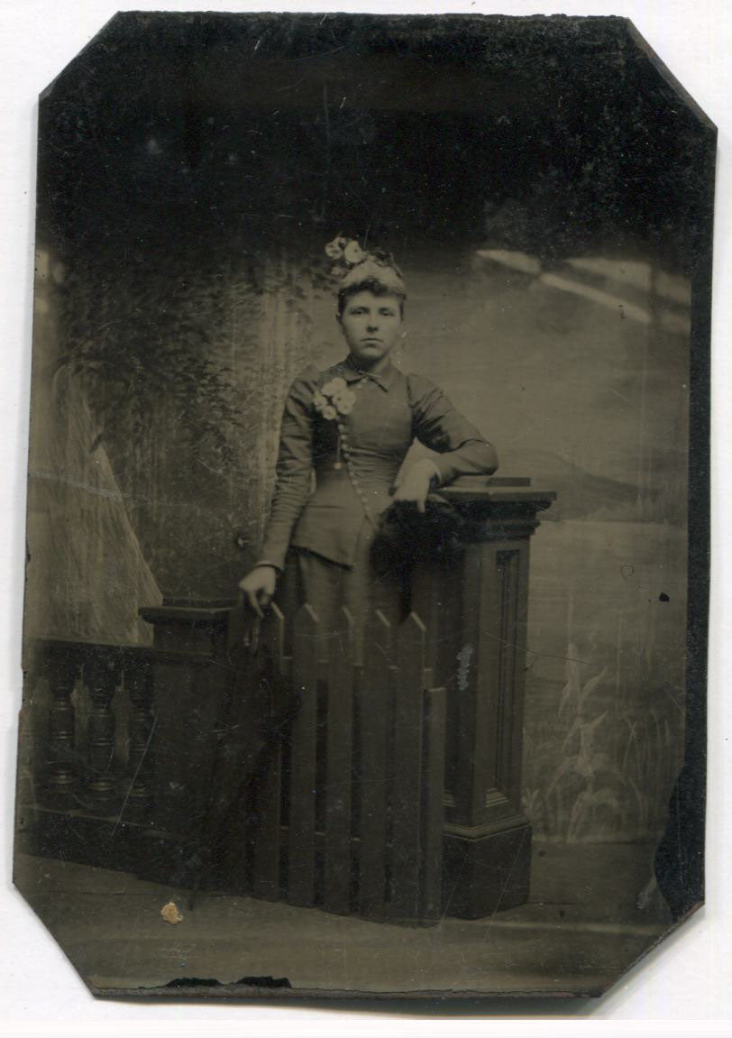 Tintype Photograph of a Pretty Lady with Flowers Standing Behind a Fence