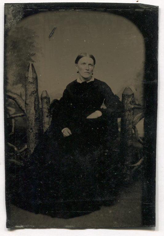 Tintype Photograph of a Woman Seated in Front of an Adirondack Fence